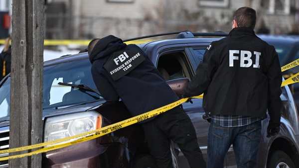 A bullet hole is seen in the windshield as law enforcement officers work at the scene of a shooting involving federal law enforcement agents, Wednesday, Jan. 7, 2026, in Minneapolis.
