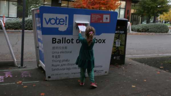 FILE -Olive, 4, deposits an election ballot into a drop box in Seattle, Wash. under the supervision of her mother, on Nov. 4, 2025. (AP Photo/Cedar Attanasio, File)