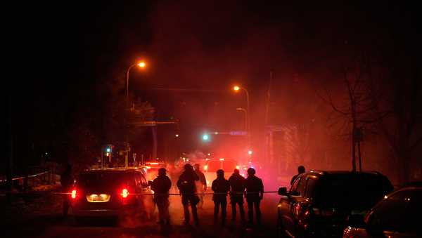 Tear gas surrounds federal law enforcement officers as they leave a scene after a shooting on Wednesday, Jan. 14, 2026, in Minneapolis.
