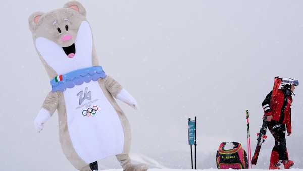 An Olympic mascot dances near the finish line of an alpine ski women's downhill training, at the 2026 Winter Olympics, in Cortina d'Ampezzo, Italy, Saturday, Feb. 7, 2026. (AP Photo/Robert F. Bukaty)