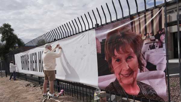 Jeff Robb, a Seattle resident wintering in Tucson, signs a banner supporting Nancy Guthrie in Tucson Ariz., on Friday, Feb. 13, 2026.