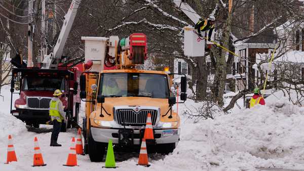 A electrical line crew from Connecticut and a tree clearing crew from Rhode Island work to restore power after a winter storm dumped more than two feet of snow across the region, Wednesday, Feb. 25, 2026, in Plymouth, Mass. (AP Photo/Charles Krupa)