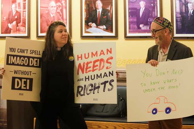 The Rev. Dr. Mandy Todd, left, pastor of Messiah Lutheran Church in Lindsborg, Kan., and Rabbi Moti Rieber, right, executive director of Kansas Interfaith Action, protest a new Kansas law that will invalidate hundreds of driver's licenses and birth certificates for transgender people that reflect their gender identities, Monday, Feb. 16, 2026, outside the Kansas Senate chamber in the Statehouse in Topeka, Kan. (AP Photo/John Hanna)