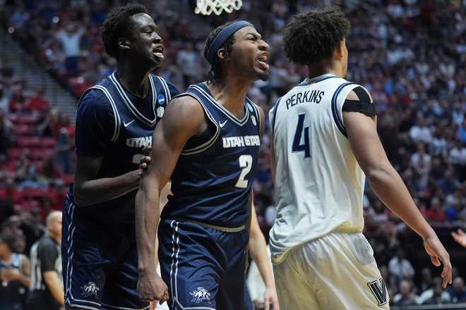 Utah State guard MJ Collins (2) and forward Adlan Elamin, left, celebrate next to Villanova guard Tyler Perkins (4) during the second half in the first round of the NCAA college basketball tournament, Friday, March 20, 2026, in San Diego.