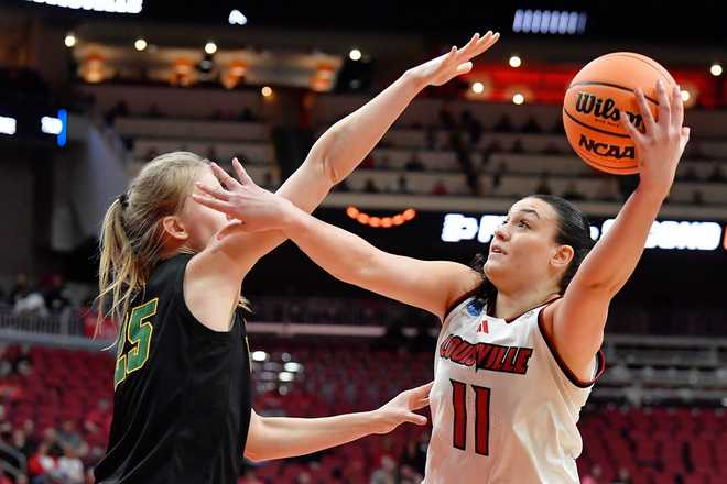 Louisville forward Elif Istanbulluoglu (11) attempts a shot over Vermont center Nikola Priede (25) during the second half in the first round of the NCAA college basketball tournament, Saturday, March 21, 2026 in Louisville, Ky. (AP Photo/Timothy D. Easley)