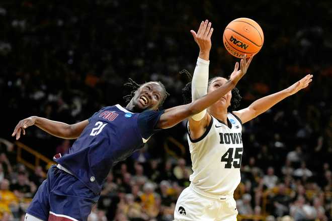 Fairleigh Dickinson guard Rebecca Osei-Owusu (21) fights for a rebound with Iowa forward Hannah Stuelke (45) during the first half in the first round of the NCAA college basketball tournament, Saturday, March 21, 2026, in Iowa City, Iowa. (AP Photo/Charlie Neibergall)