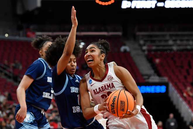 Alabama guard Diana Collins (20) drives to the basket against Rhode Island guard Sophia Vital (15) during the first half in the first round of the NCAA college basketball tournament, Saturday, March 21, 2026 in Louisville, Ky. (AP Photo/Timothy D. Easley)