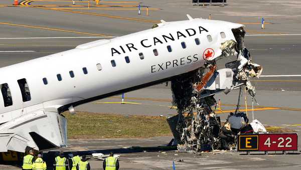 Aircraft maintenance workers arrive to inspect the wreckage of an Air Canada Express jet, Tuesday, March 24, 2026, just off the runway where it had collided with a Port Authority fire truck Sunday night at LaGuardia Airport in New York. (