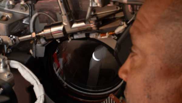 In this photo provided by NASA, Artemis II pilot and NASA astronaut Victor Glover peers out one of the Orion spacecraft's windows looking back at Earth ahead of the crew's lunar flyby, Monday, April 6, 2026.(NASA via AP)