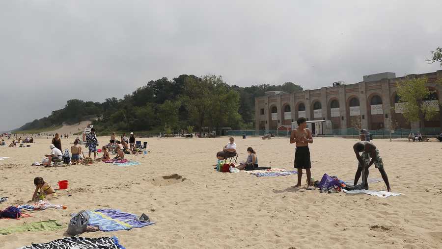 In this Aug. 10, 2015, photo, visitors relax at The Dunes State Park pavilion beach near the park's dilapidated pavilion in Chesterton, Ind. State officials Tuesday, Oct. 6, 2015 upheld a local board's decision denying a liquor license to a politically connected developer who won a contract to bring a restaurant, bar and banquet hall to the beachfront. (AP Photo/Christian K. Lee, File)