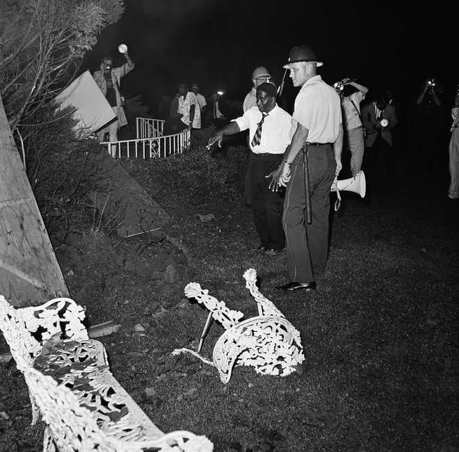 The black lawyer Arthur Shores and a police officer inspect September 4, 1963 Damage in Shore in Birmingham, Ala. (AP photo)