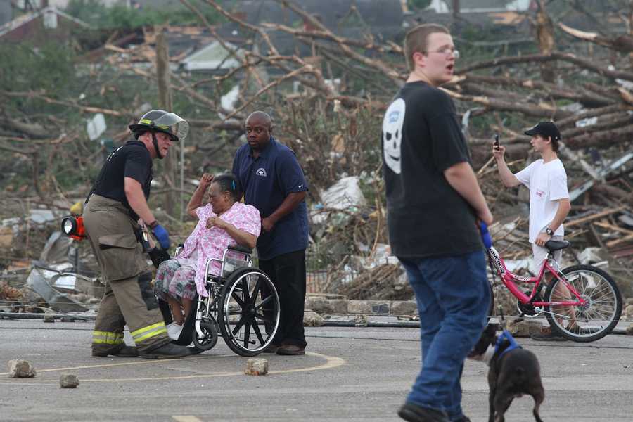 April 27 2011 Tuscaloosa Tornado Alabama tornadoes A woman is helped into her wheelchair after being rescued from an apartment building that was demolished by a tornado Wednesday, April 27, 2011 Tuscaloosa, Ala. A wave of severe storms laced with tornadoes strafed the South on Wednesday, killing at least 16 people around the region and splintering buildings across swaths of an Alabama university town. (AP Photo/Caroline Summers)