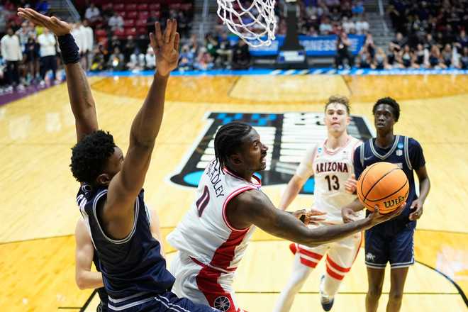 Arizona guard Jaden Bradley (0) shoots around Utah State forward Garry Clark (11) during the second half of a game in the second round of the NCAA college basketball tournament Sunday, March 22, 2026.