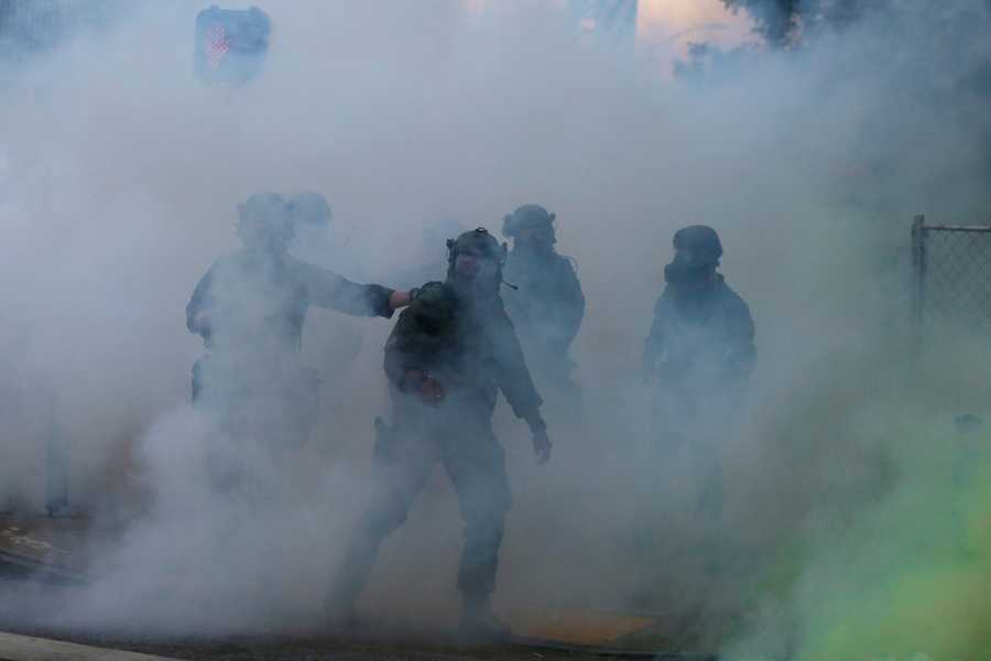 Police move through gas as demonstrators march, Sunday, May 31, 2020, in Atlanta.
