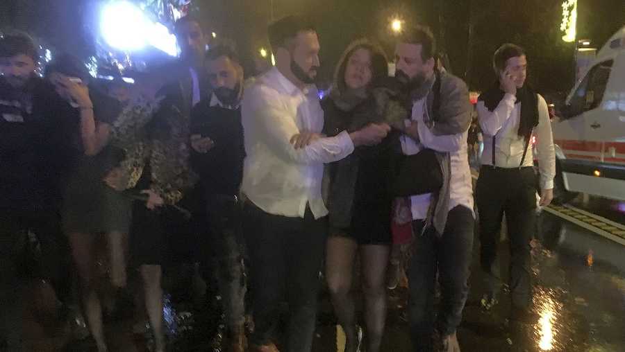People leave the nightclub, the scene of an attack in Istanbul, early Sunday, Jan. 1, 2017. An assailant believed to have been dressed in a Santa Claus costume and armed with a long-barrelled weapon, opened fire at a nightclub in Istanbul's Ortakoy district during New Year's celebrations, killing dozens of people and wounding dozens of others in what the province's governor described as a terror attack.