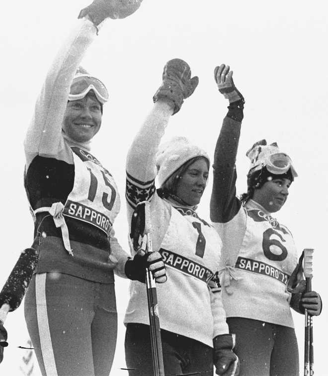 FILE - Barbara Ann Cochran, center, of the United States, winner of the Winter Olympic women&amp;apos;s slalom gold medal, stands with Florence Steurer (15), the bronze medalist, and Daniele Debernard (6) the silver medalist both from France, in Sapporo, Japan on Feb. 11, 1972. Fifty years after his mom, Barbara Ann, won the gold in slalom, Ryan Cochran-Siegle is contending for a medal in the men&amp;apos;s downhill that will open the Alpine skiing program of the Beijing Games on Sunday.(AP Photo/ Sal Veder, File)