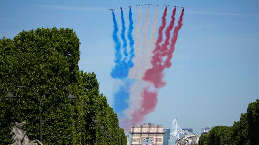 Alphajets of the Patrouille de France fly over the Champs-Elysees avenue during the Bastille Day parade Thursday, July 14, 2022 in Paris. France is celebrating its national holiday with thousands of French troops marching down the Champs-Elysees avenue alongside allies from Eastern Europe. (AP Photo/Christophe Ena)