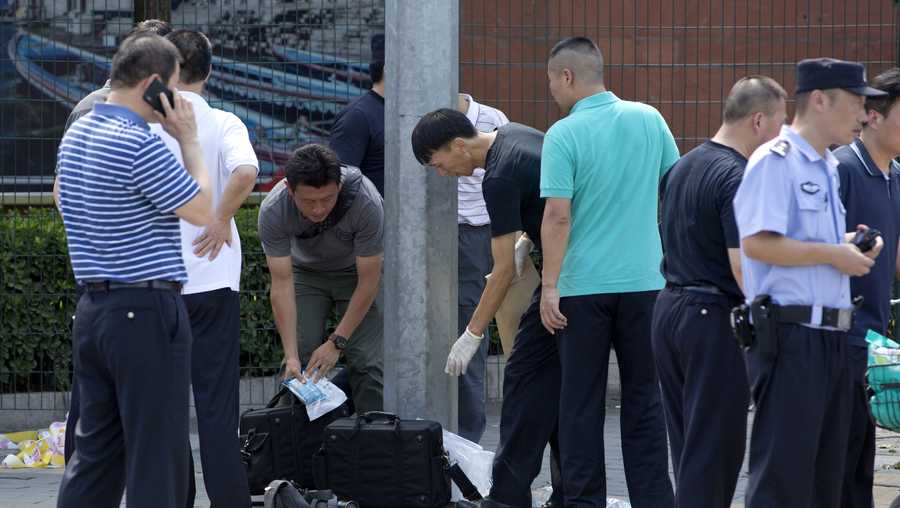 Chinese officials work near the site of a reported blast just south of the U.S. Embassy in Beijing, Thursday, July 26, 2018.