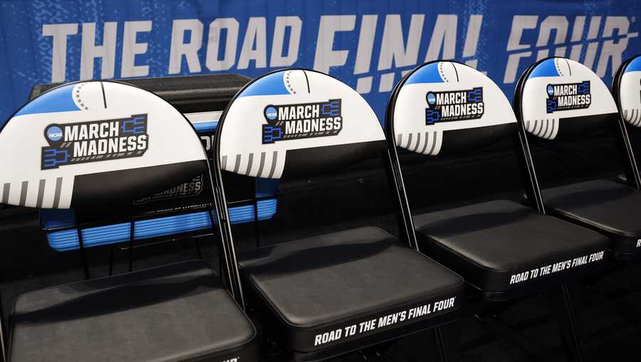 March Madness logos adorn seats at a first-round college basketball game.