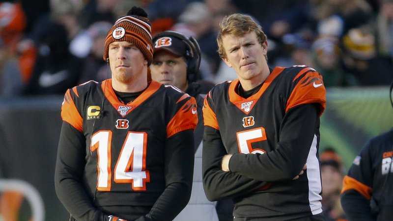 Cincinnati Bengals quarterbacks Andy Dalton (14) and Ryan Finley (5) stand on the sidelines during the second half an NFL football game against the Pittsburgh Steelers, Sunday, Nov. 24, 2019, in Cincinnati. (AP Photo/Frank Victores)