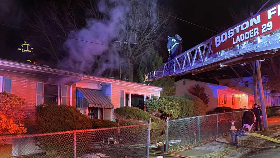 Firefighters work to extinguish a burning home in Mattapan, Dec. 29, 2020