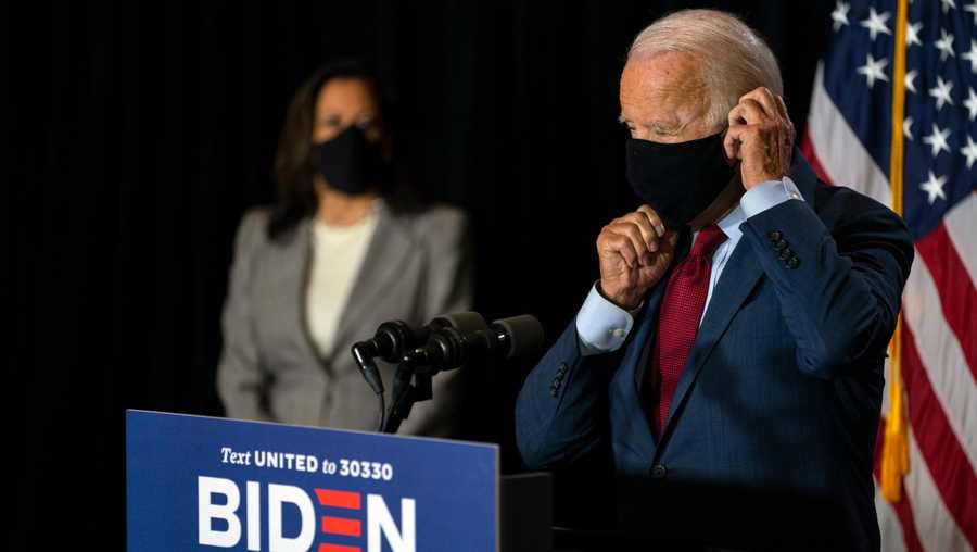 Democratic presidential candidate former Vice President Joe Biden joined by his running mate Sen. Kamala Harris, D-Calif., replaces his face mask after speaking at the Hotel DuPont in Wilmington, Del., Thursday, Aug. 13, 2020.
