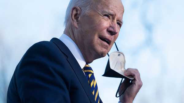 President Joe Biden removes a protective mask before speaking about the constitutional right to vote at the Atlanta University Center Consortium in Atlanta, Georgia on Jan. 11, 2022.