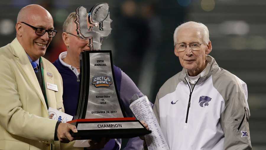 Kansas State head coach Bill Snyder, right, accepts the trophy after defeating UCLA 35-17 during an NCAA college football Cactus Bowl game, Tuesday, Dec. 26, 2017, in Phoenix. (AP Photo/Rick Scuteri)