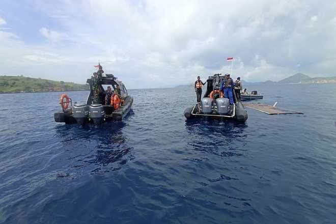 In this photo released by the Indonesian National Search and Rescue Agency (BASARNAS) on Saturday, Dec. 27, 2025, rescuers examine the waters where a debris believed to be from a tour boat that sank was found, near Padar Island within Komodo National Park, Indonesia.