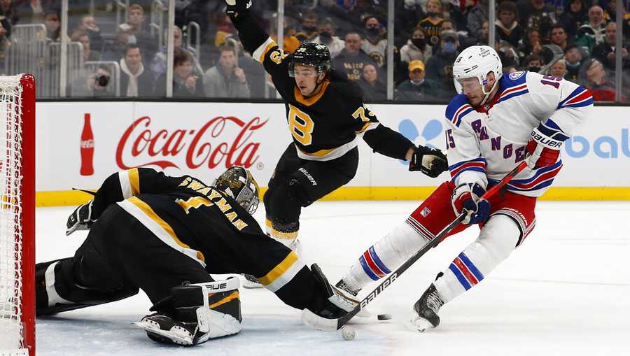 Boston Bruins goaltender Jeremy Swayman knocks the puck away from New York Rangers&apos; Julien Gauthier during the first period of an NHL hockey game Friday, Nov. 26, 2021, in Boston. (AP Photo/Winslow Townson)