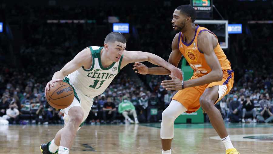 Boston Celtics guard Payton Pritchard (11) drives against Phoenix Suns forward Mikal Bridges (25) during the second half of an NBA basketball game, Friday, Dec. 31, 2021, in Boston. (AP Photo/Mary Schwalm)