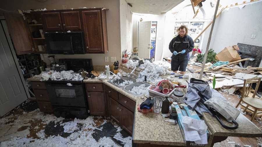 Luke Schockley moves debris from a tornado inside his parent in-law&apos;s house in Bowling Green, Ky., Saturday, Dec. 11, 2021. A monstrous tornado killed dozens of people in Kentucky and the toll was climbing Saturday after severe weather ripped through at least five states, leaving widespread devastation. (AP Photo/Michael Clubb)