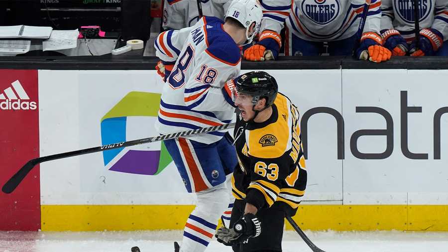Edmonton Oilers left wing Zach Hyman (18) and Boston Bruins left wing Brad Marchand (63) vie for control of the puck in the first period of an NHL hockey game, Thursday, March 9, 2023, in Boston.