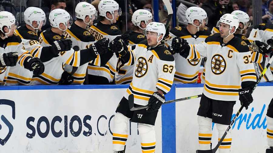 Boston Bruins left wing Brad Marchand (63) celebrates his goal against the Tampa Bay Lightning with the bench during the second period of an NHL hockey game Saturday, Jan. 8, 2022, in Tampa, Fla. (AP Photo)