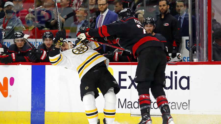 Carolina Hurricanes&apos; Brett Pesce (22) collides with Boston Bruins&apos; Brad Marchand (63) during the first period of Game 2 of an NHL hockey Stanley Cup first-round playoff series in Raleigh, N.C., Wednesday, May 4, 2022. (AP Photo/Karl B DeBlaker)