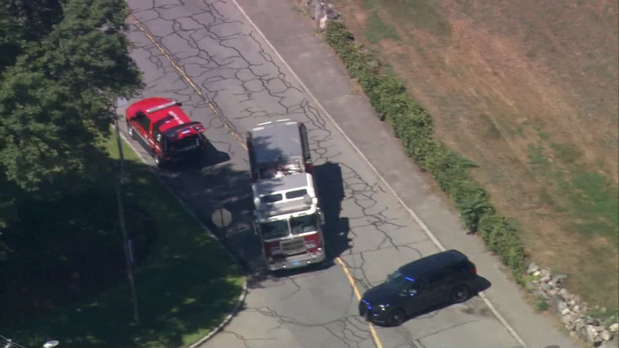 Emergency vehicles block a road near Brandeis University while investigating a bomb threat