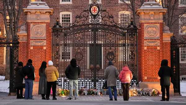 Visitors pause at a makeshift memorial for the victims of Saturday's shooting, at the Van Wickle Gate at Brown University, Monday, Dec. 15, 2025, in Providence, R.I.(AP Photo/Robert F. Bukaty)