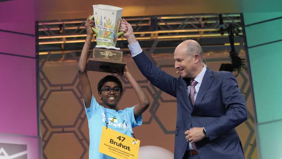 Bruhat Soma, 12, of Tampa, Fla., accepts the trophy from E.W. Scripps Company president and CEO Adam Symson after winning the Scripps National Spelling Bee.