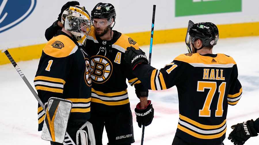 Boston Bruins goaltender Jeremy Swayman (1) is congratulated by David Krejci, center, and Taylor Hall (71) after the team's 3-2 win over Buffalo Sabres in a shootout in an NHL hockey game Tuesday, April 13, 2021, in Boston. (AP Photo)