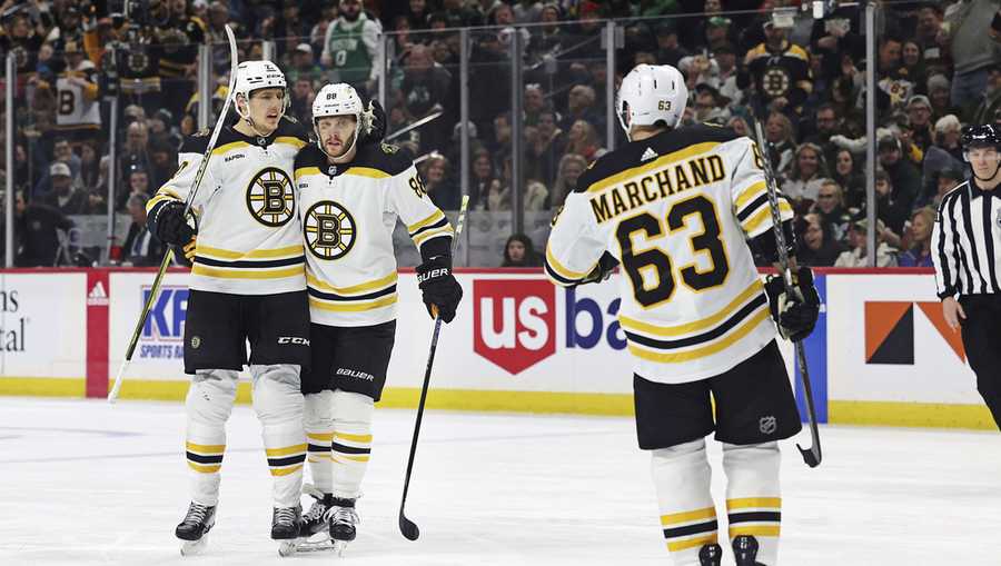 Boston Bruins right wing David Pastrnak (88) celebrates with defenseman Hampus Lindholm (27) after Pastrnak scored a goal during the second period of an NHL hockey game Sunday, March 18, 2023, in St. Paul, Minn. Boston won 5-2. (AP Photo/Stacy Bengs)