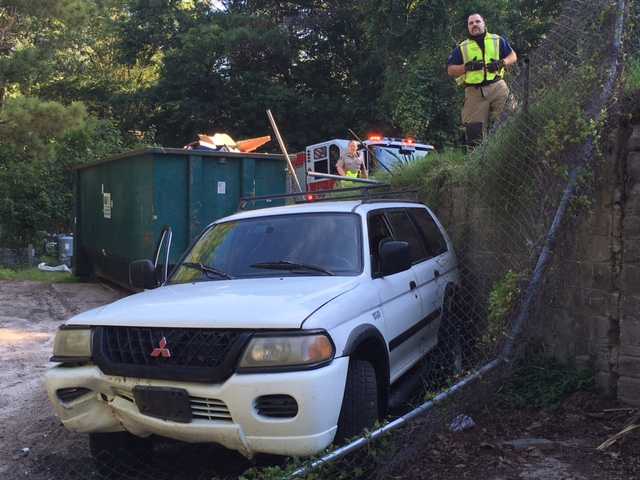 SUV lands in trash bins at Burton dump