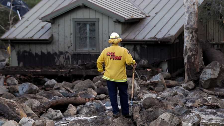 A firefighter walks among the rocks and mud left by a mudslide Wednesday, Jan. 10, 2018, in Montecito, Calif. Anxious family members awaited word on loved ones Wednesday as rescue crews searched grimy debris and ruins for more than a dozen people missing after mudslides in Southern California destroyed houses, swept cars to the beach and left more than a dozen victims dead.