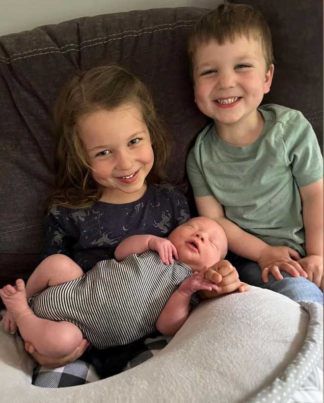 Cora&#x20;Clancy&#x20;holds&#x20;her&#x20;baby&#x20;brother,&#x20;Callan,&#x20;while&#x20;sitting&#x20;next&#x20;to&#x20;her&#x20;younger&#x20;brother,&#x20;Dawson.