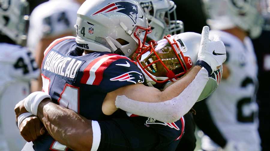 New England Patriots quarterback Cam Newton, right, gives running back Rex Burkhead a lift after Burkhead's touchdown in the second half of an NFL football game against the Las Vegas Raiders, Sunday, Sept. 27, 2020, in Foxborough, Mass.(AP Photo/Charles Krupa)