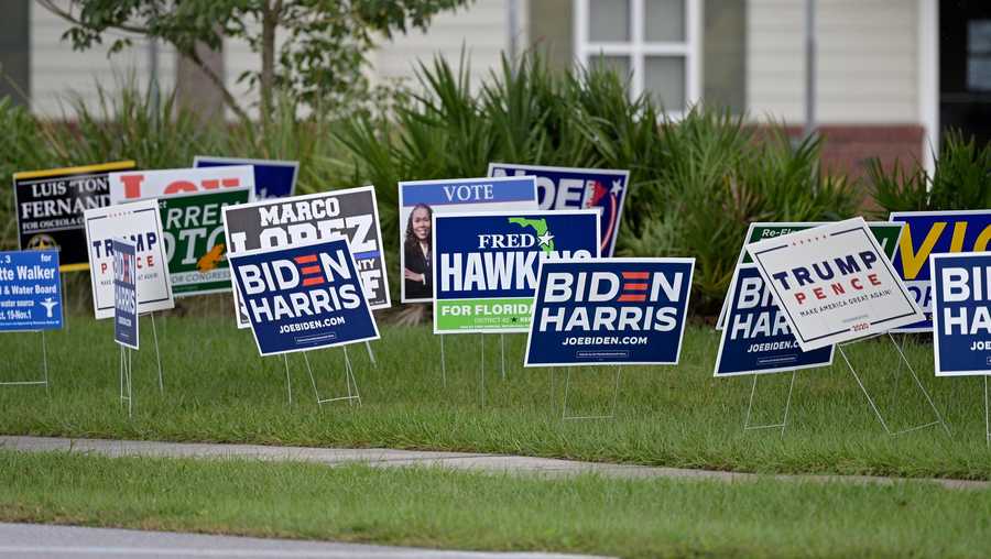 Campaign signs are seen outside an early voting location Monday, Oct. 26, 2020, in Kissimmee, Fla.