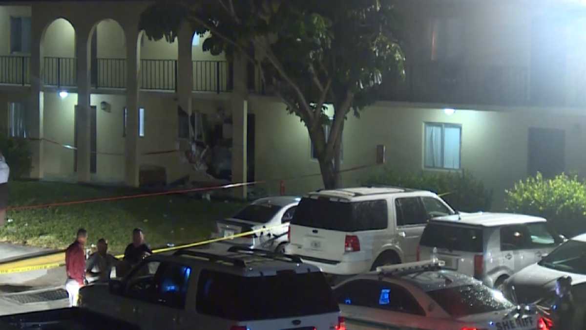 Police ID men found dead in car that crashed into apartment