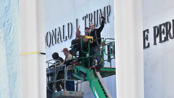 Workers install Donald J. Trump above the current signage on the Kennedy Center on Friday, Dec. 19, 2025, in Washington.