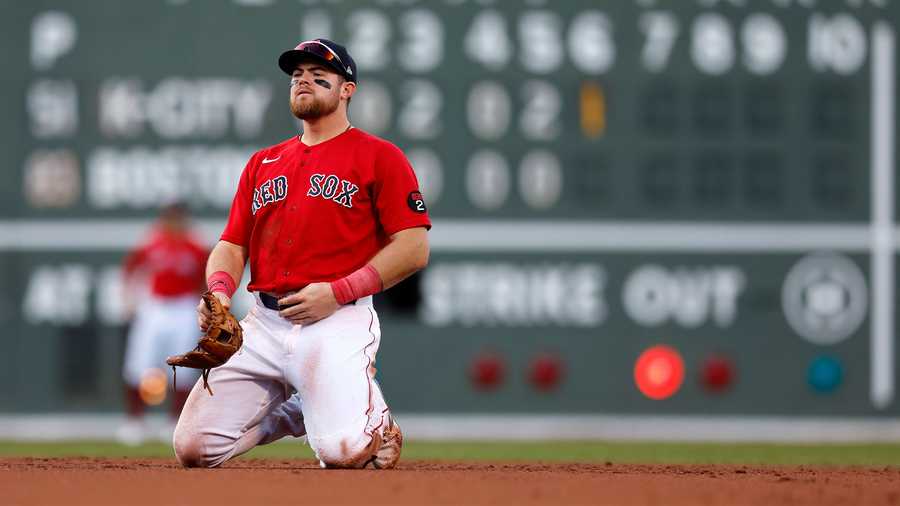 Boston Red Sox's Christian Arroyo kneels after fielding the RBI single by Kansas City Royals' MJ Melendez during the sixth inning of a baseball game, Saturday, Sept. 17, 2022, in Boston.
