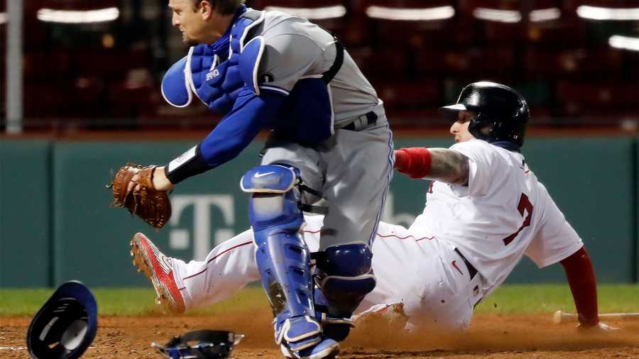 Boston Red Sox's Christian Vazquez (7) scores the winning run next to Toronto Blue Jays' Caleb Joseph during the ninth inning of a baseball game Saturday, Sept. 5, 2020, in Boston. (AP Photo/Michael Dwyer)