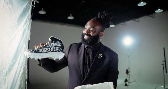 New Orleans Saints linebacker Demario Davis shows off his cleats representing Stand Together.